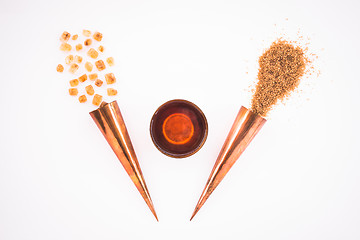 Image showing Cup of tea and copper cones with sugar