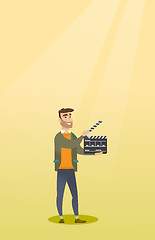 Image showing Smiling man holding an open clapperboard.