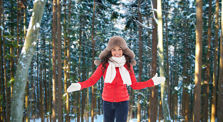 Image showing happy woman in fur hat over winter forest