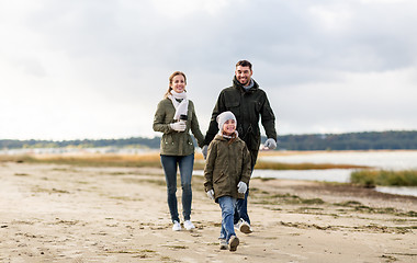 Image showing happy family walking along autumn beach