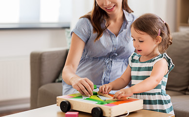 Image showing pregnant mother and daughter with toy blocks