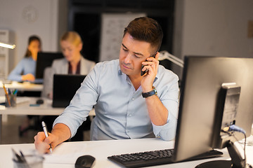 Image showing man calling on smartphone at night office