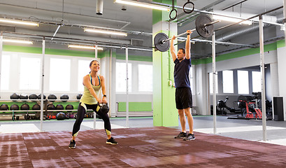 Image showing man and woman with weights exercising in gym