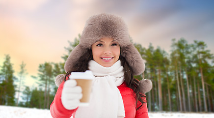 Image showing woman in fur hat with coffee over winter forest