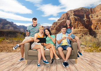 Image showing friends with modern gadgets over grand canyon