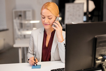 Image showing businesswoman calling on sartphone at night office