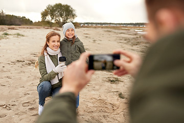 Image showing family photographing by smartphone on autumn beach