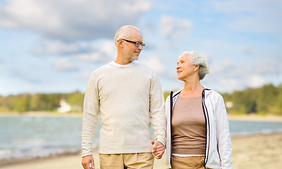 Image showing happy senior couple over beach background