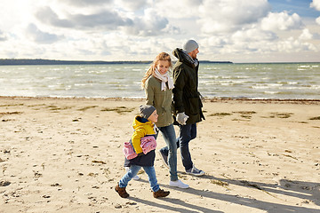 Image showing happy family going to picnic on beach in autumn