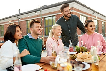 Image showing happy friends with drinks or bbq party on rooftop