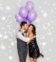 Image showing happy couple with violet balloons kissing at party