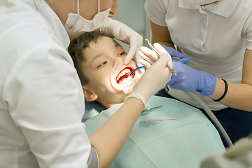 Image showing Orthodontist examining boy mouth