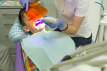 Image showing Orthodontist examining boy mouth