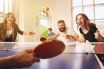 Image showing Group of happy young friends playing ping pong table tennis