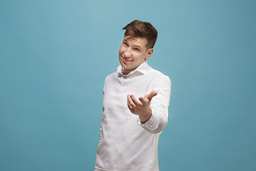 Image showing The happy business man standing and smiling against studio background.