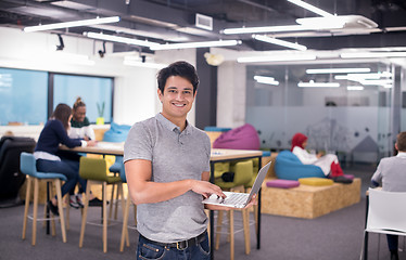 Image showing portrait of young indian businessman using laptop computer