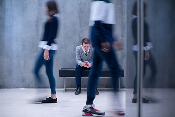 Image showing businessman using mobile phone while sitting on the bench