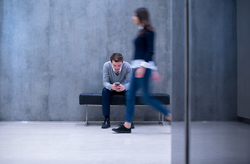 Image showing businessman using mobile phone while sitting on the bench