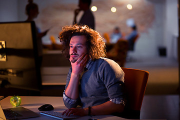 Image showing man working on computer in dark office