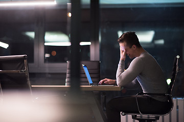 Image showing man working on laptop in dark office