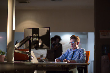 Image showing man working on computer in dark office