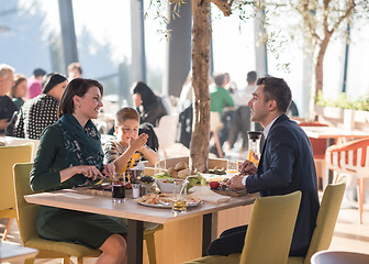 Image showing Young parents enjoying lunch time with their children