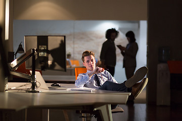 Image showing businessman sitting with legs on desk at office