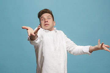 Image showing Beautiful male half-length portrait isolated on studio backgroud. The young emotional surprised man