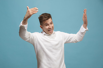 Image showing Beautiful male half-length portrait isolated on studio backgroud. The young emotional surprised man