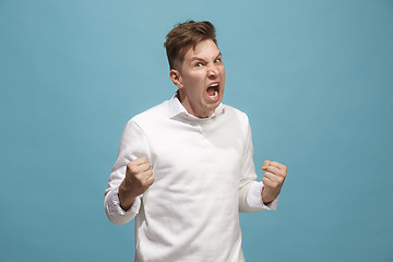 Image showing The young emotional angry man screaming on studio background