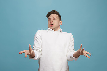 Image showing Beautiful male half-length portrait isolated on studio backgroud. The young emotional surprised man