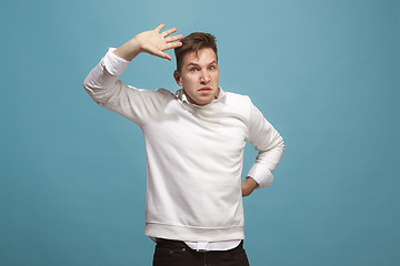 Image showing Beautiful male half-length portrait isolated on studio backgroud. The young emotional surprised man