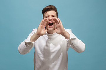 Image showing Isolated on pink young casual man shouting at studio