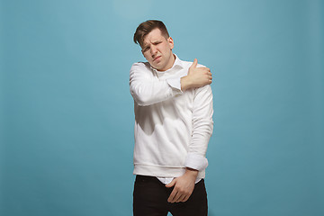 Image showing Young man overwhelmed with a pain in the shoulder