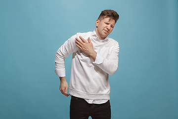 Image showing Young man overwhelmed with a pain in the shoulder