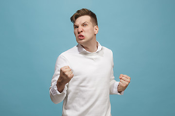 Image showing The young emotional angry man screaming on studio background