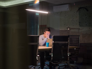 Image showing man working on laptop in dark office