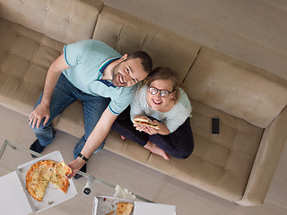 Image showing couple eating pizza in their luxury home villa