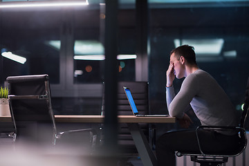 Image showing man working on laptop in dark office