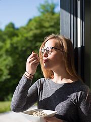 Image showing woman eating breakfast in front of her luxury home villa