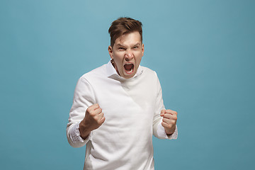 Image showing The young emotional angry man screaming on studio background