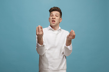 Image showing Beautiful male half-length portrait isolated on studio backgroud. The young emotional surprised man