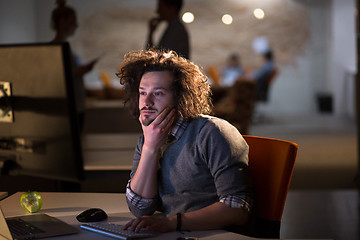 Image showing man working on computer in dark office