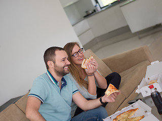 Image showing couple eating pizza in their luxury home villa