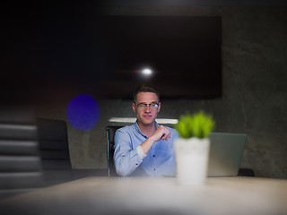 Image showing man working on laptop in dark office