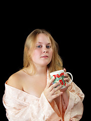 Image showing Young plump woman in robe with coffee cup