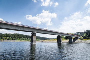 Image showing Bridge over a lake with a forest in the background