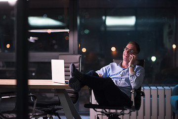 Image showing businessman using mobile phone in dark office