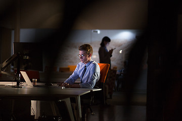 Image showing man working on computer in dark office