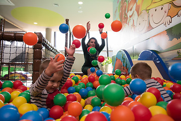 Image showing Young mom with her kids in a children\'s playroom